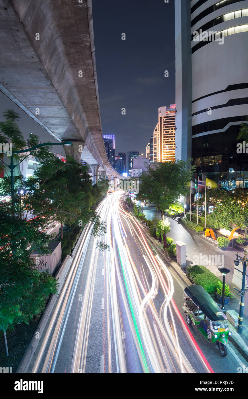 Vista di elevazione via dello skytrain e traffico sentieri di luce sulla Strada di Sukhumvit Road nel centro cittadino di Bangkok, Thailandia, Sud-est asiatico, in Asia Foto Stock