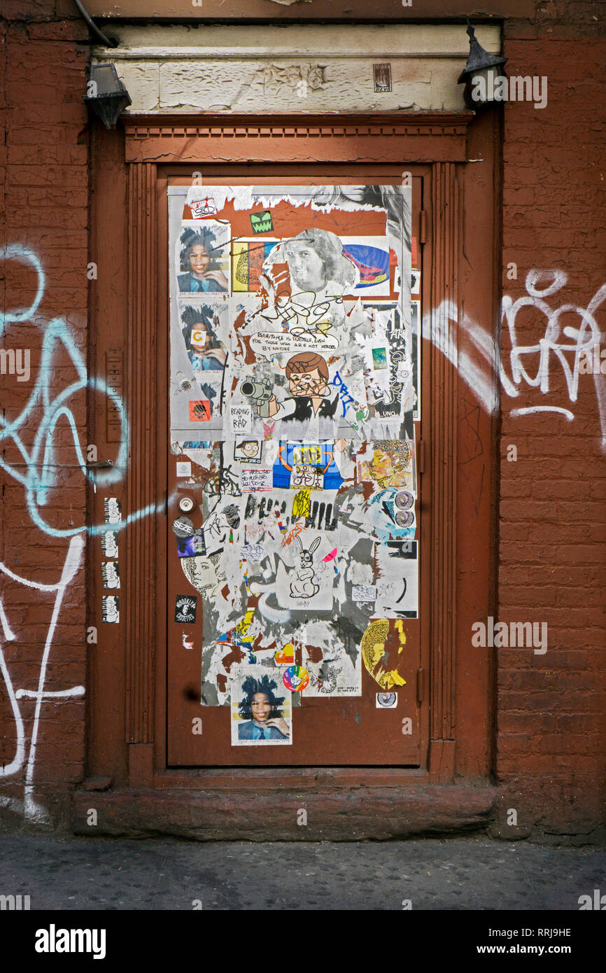 Un arte di strada collage di adesivi, disegno, graffiti e tag su una porta l'Ottava Avenue vicino a 14th Street nel Quartiere di Chelsea, Manhattan New York City Foto Stock