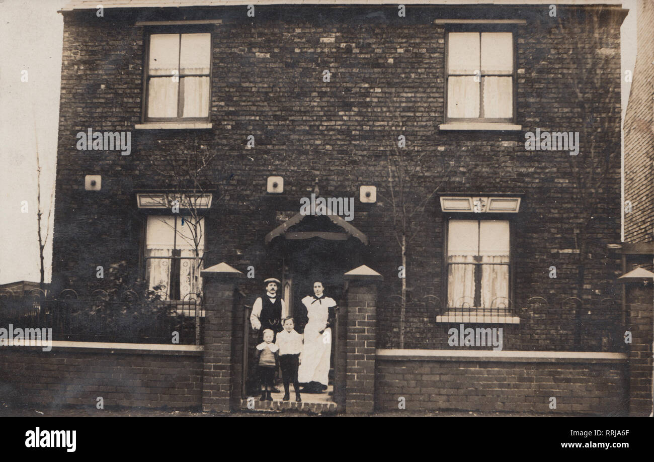 Vintage Edwardian Cartolina fotografica che mostra una famiglia si fermò presso il cancello anteriore della loro staccato Home Foto Stock