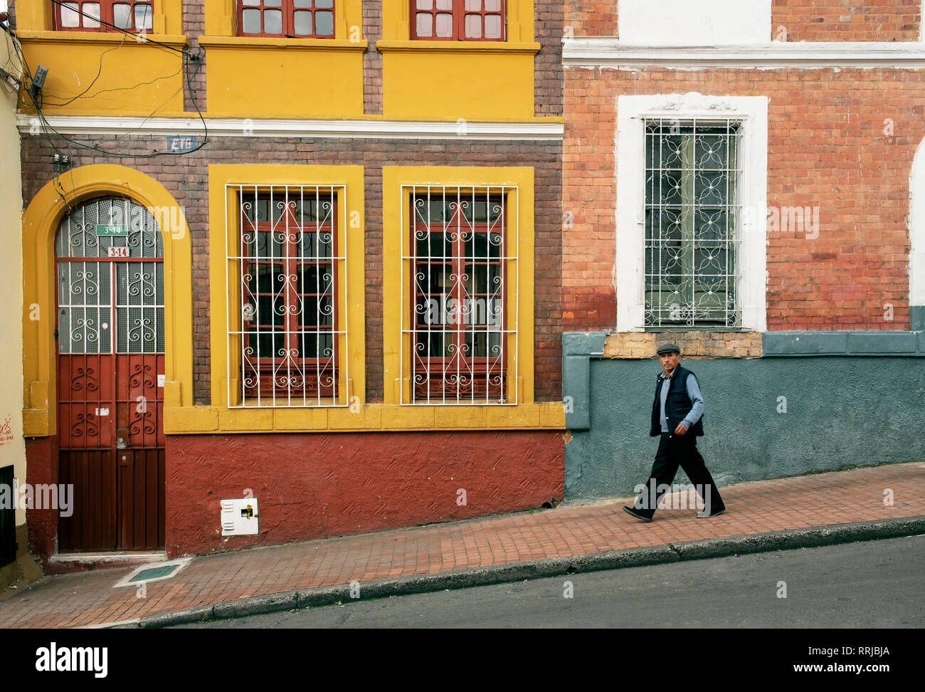 Local man walking passato edificio coloniale. La Candelaria, il centro storico di Bogotà, Colombia. Sep 2018 Foto Stock