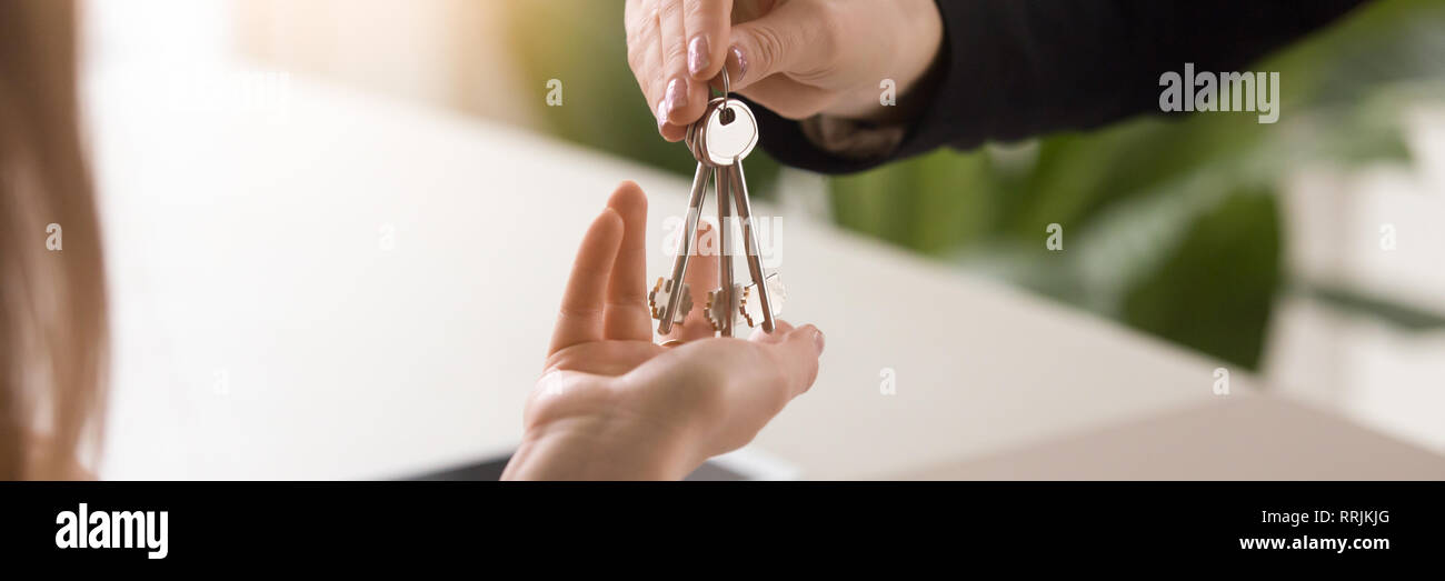 L'immagine orizzontale close up mani maschio che dà le chiavi a femmina Foto Stock
