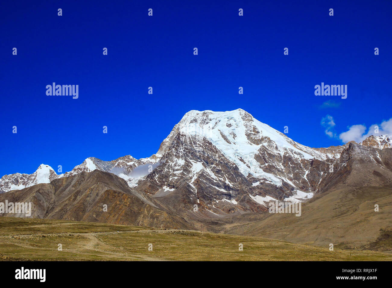 Paesaggio del profondo cielo blu ghiaccio e vette innevate delle montagne himalayane con il bianco delle nuvole durante il giorno Foto Stock