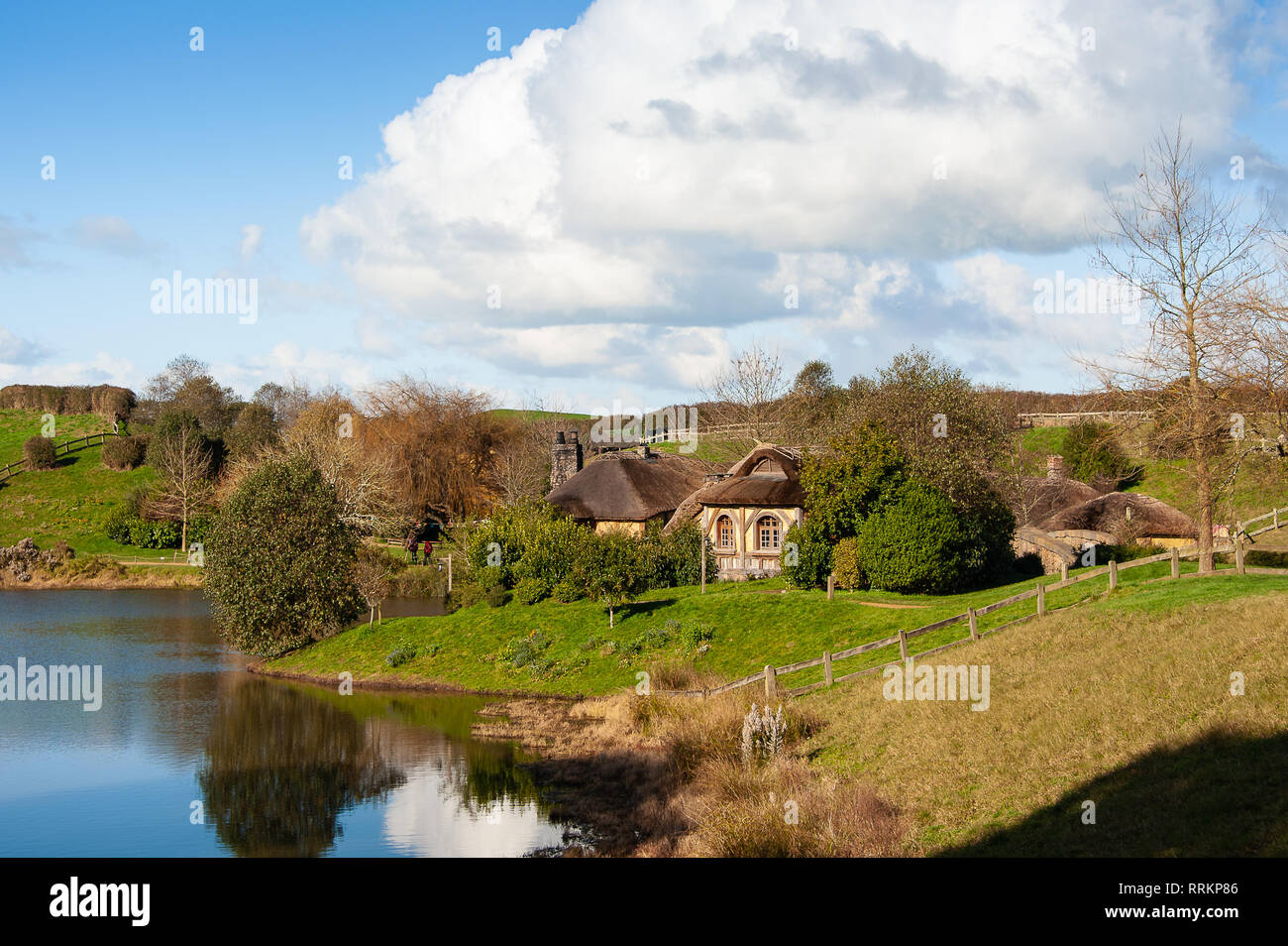 Matamata, Nuova Zelanda: Hobbiton movie set il paesaggio con le dolci colline, il Green Dragon pub e vista lago Foto Stock