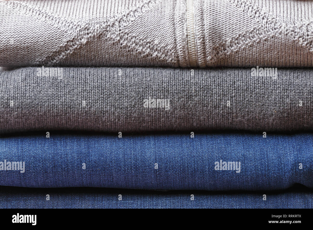 Una pila di fogli piegati vestiti in colori blu e grigio. Close-up. Foto Stock