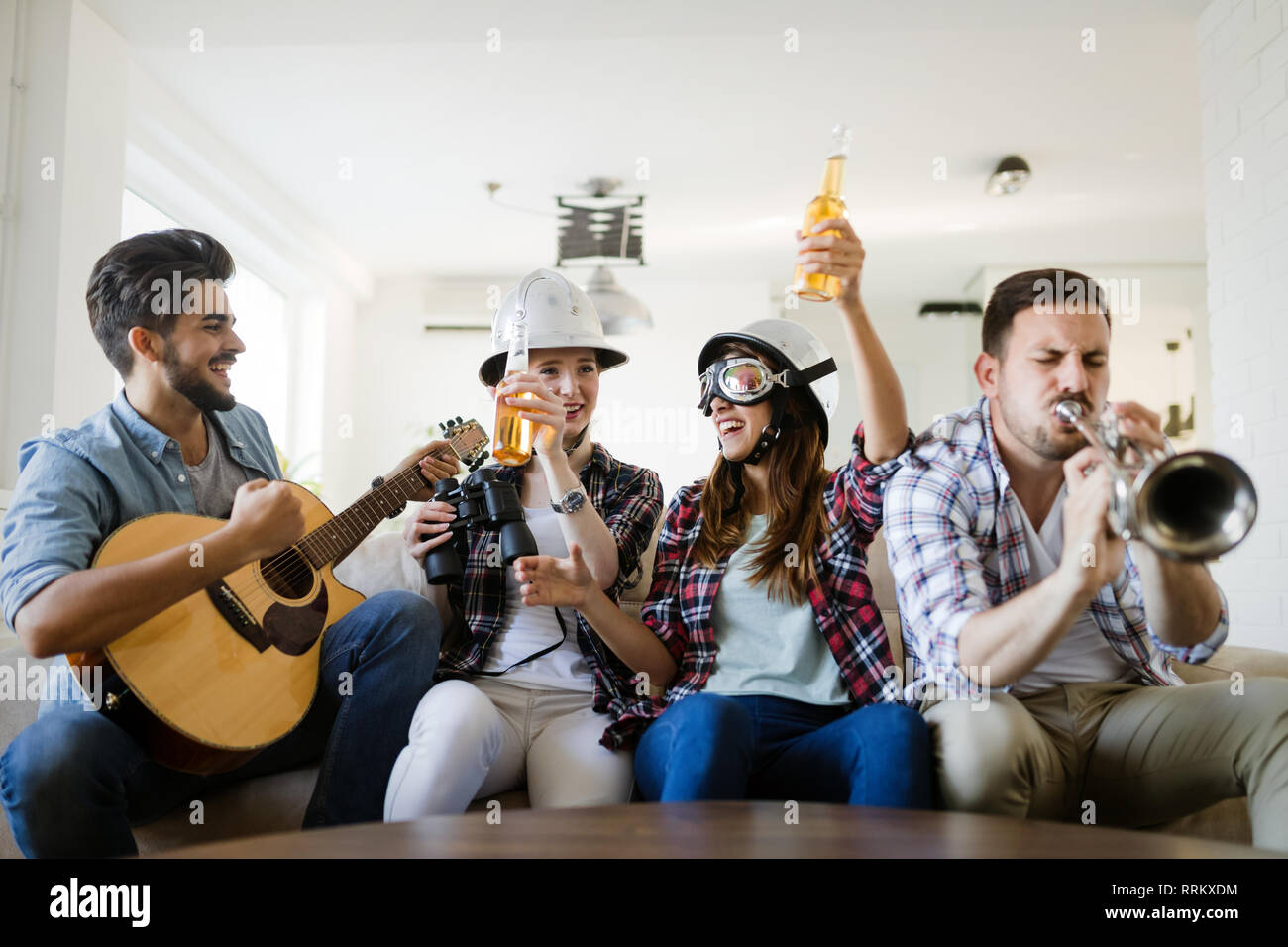 Piccolo gruppo di giovani appendere fuori all'house party, amici divertendosi Foto Stock