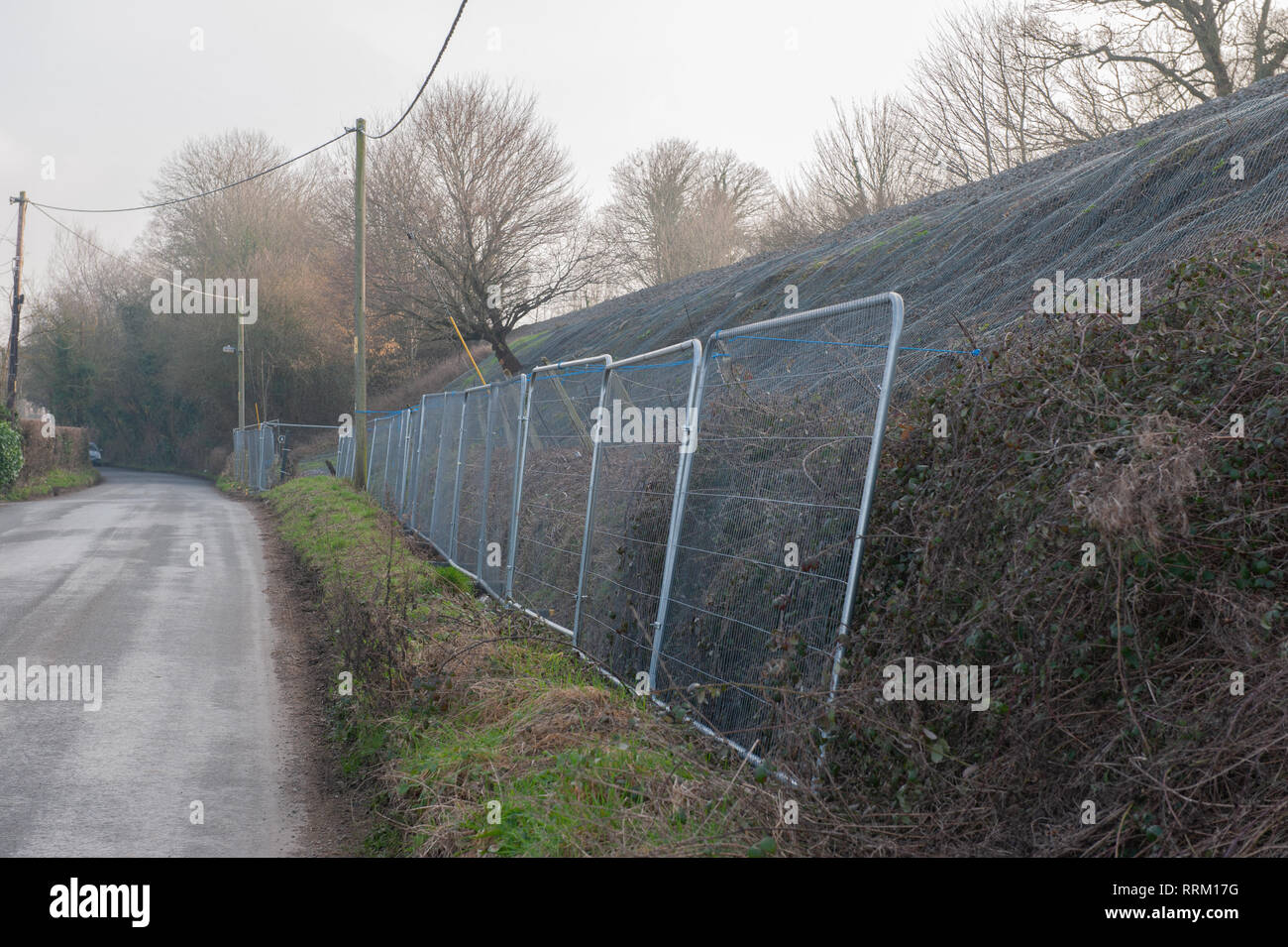 Barriere di sicurezza e una rete di protezione per i lavori in corso sulla diga ferroviaria. Foto Stock