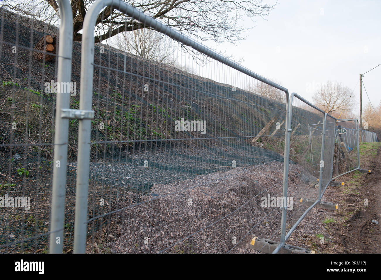 Barriere di sicurezza e una rete di protezione per i lavori in corso sulla diga ferroviaria. Foto Stock