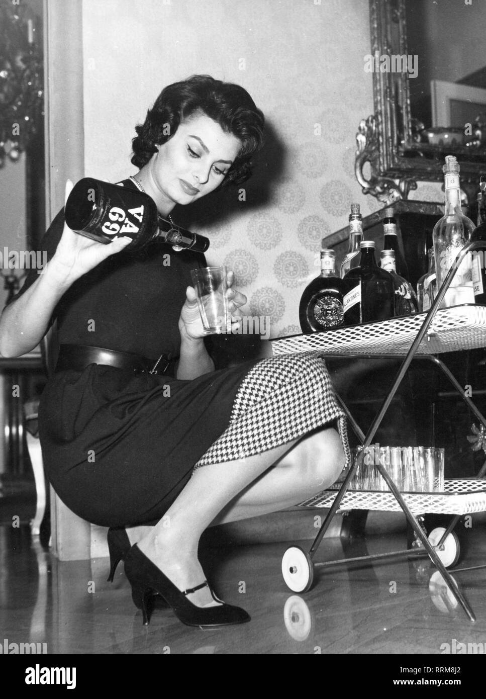 Loren, Sophia, * 20.9.1934, l'attrice italiana e mezza lunghezza, versando se stessa un bicchiere di whisky, anni cinquanta, Additional-Rights-Clearance-Info-Not-Available Foto Stock