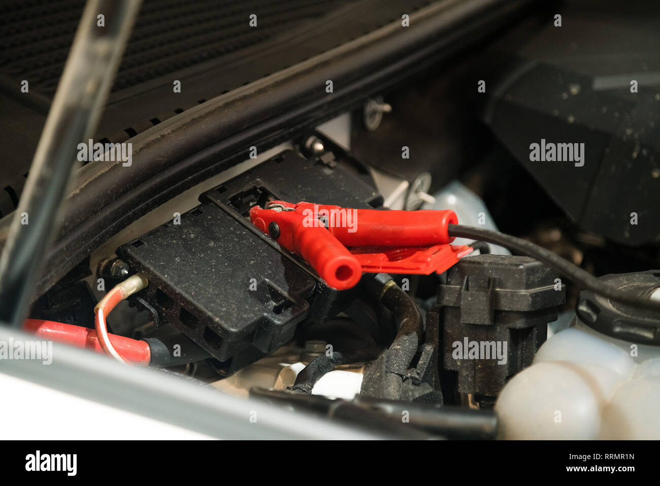 Cavo a ponticello fissato sotto il cofano per auto per aiutare avviare auto motore. Auto officina riparazioni Foto Stock