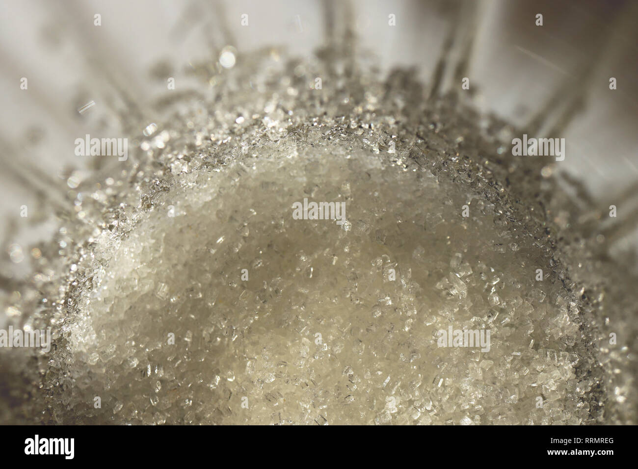 Lo zucchero al fondo di un vetro sfaccettate. Macro closeup opere d'arte. Foto Stock