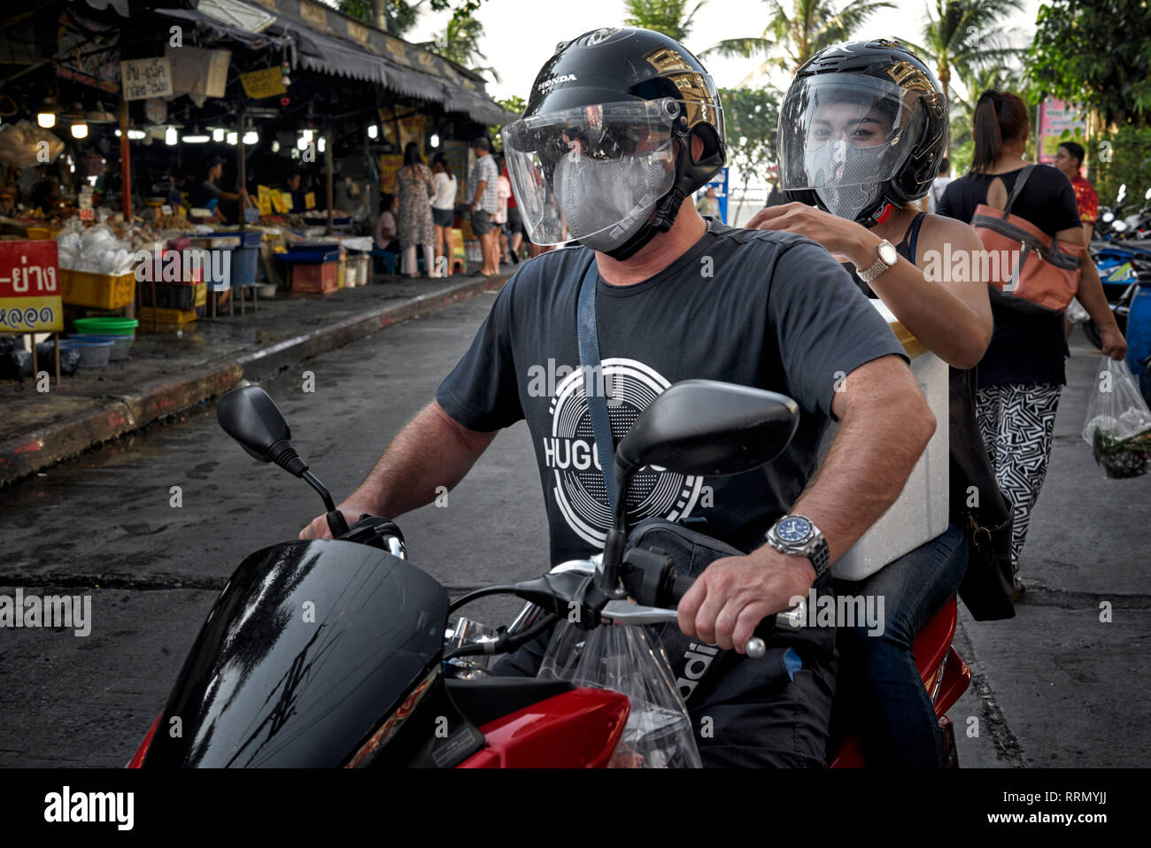 Matura in moto. L uomo e la donna in sella a una motocicletta e indossando il casco di sicurezza e il viso anti inquinamento mask Foto Stock