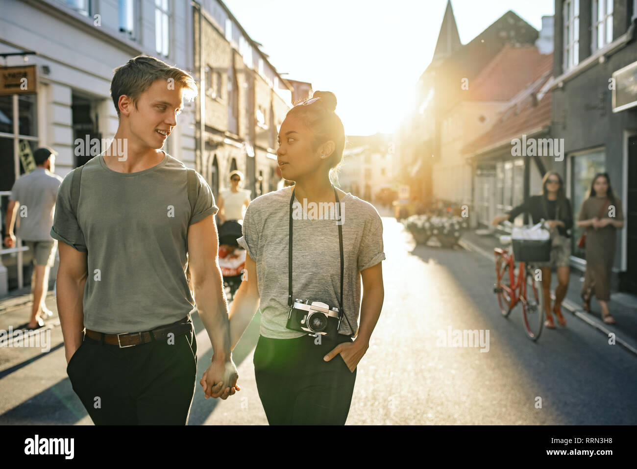 Coppia giovane sorridere mentre esplorare la città insieme a piedi Foto Stock