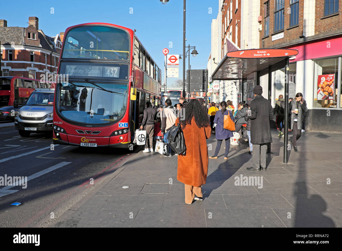 La gente a salire su un autobus 432 e i passeggeri in attesa ad una fermata del bus sulla strada di Brixton in Brixton South London SW9 Inghilterra UK KATHY DEWITT Foto Stock