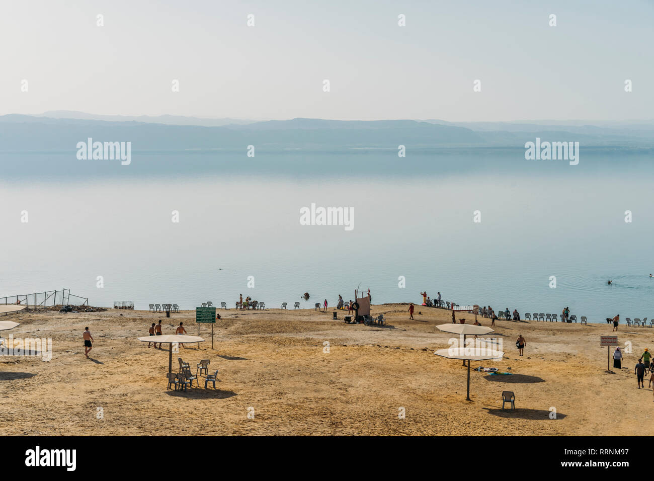 Vista panoramica spiaggia e sole lago blu, Mar Morto, Giordania Foto Stock