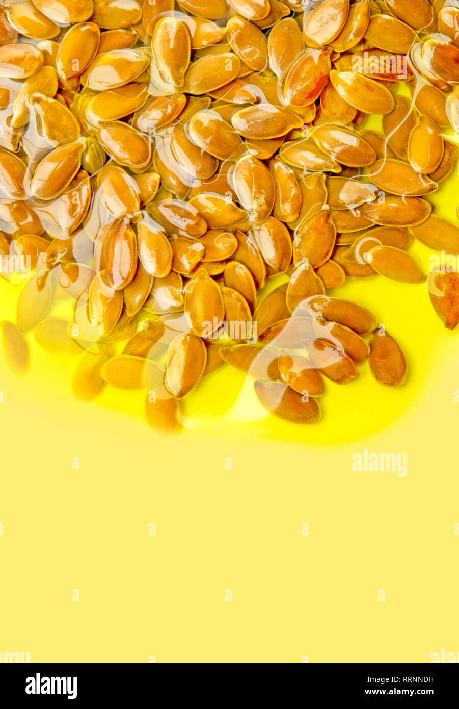 I semi di lino o semi di lino nell'olio d'oliva sul backround giallo. Gli acidi grassi polinsaturi omega 3-6-9 vitamina. Foto Stock