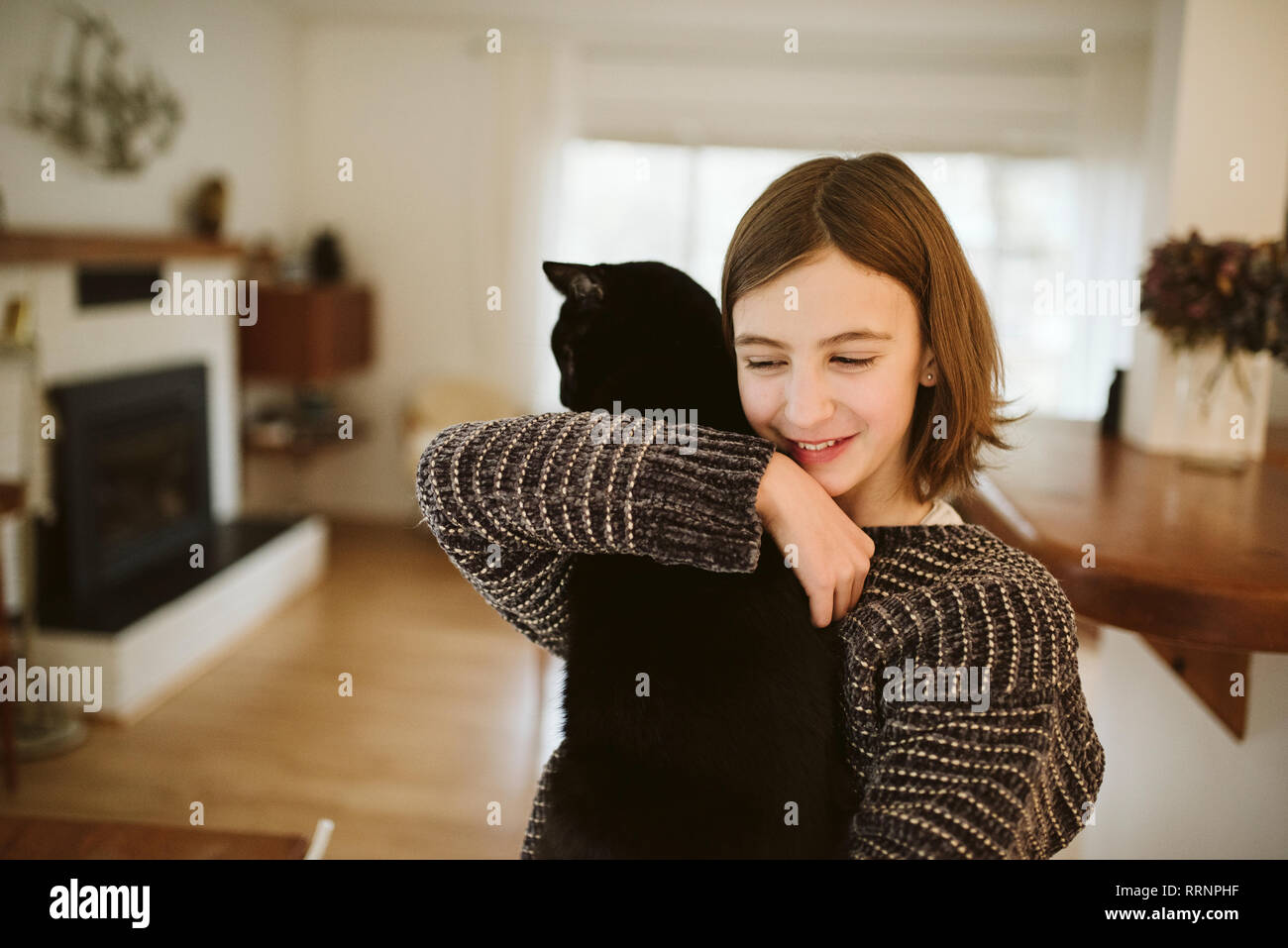 Affettuosa Ragazza con gatto nero Foto Stock