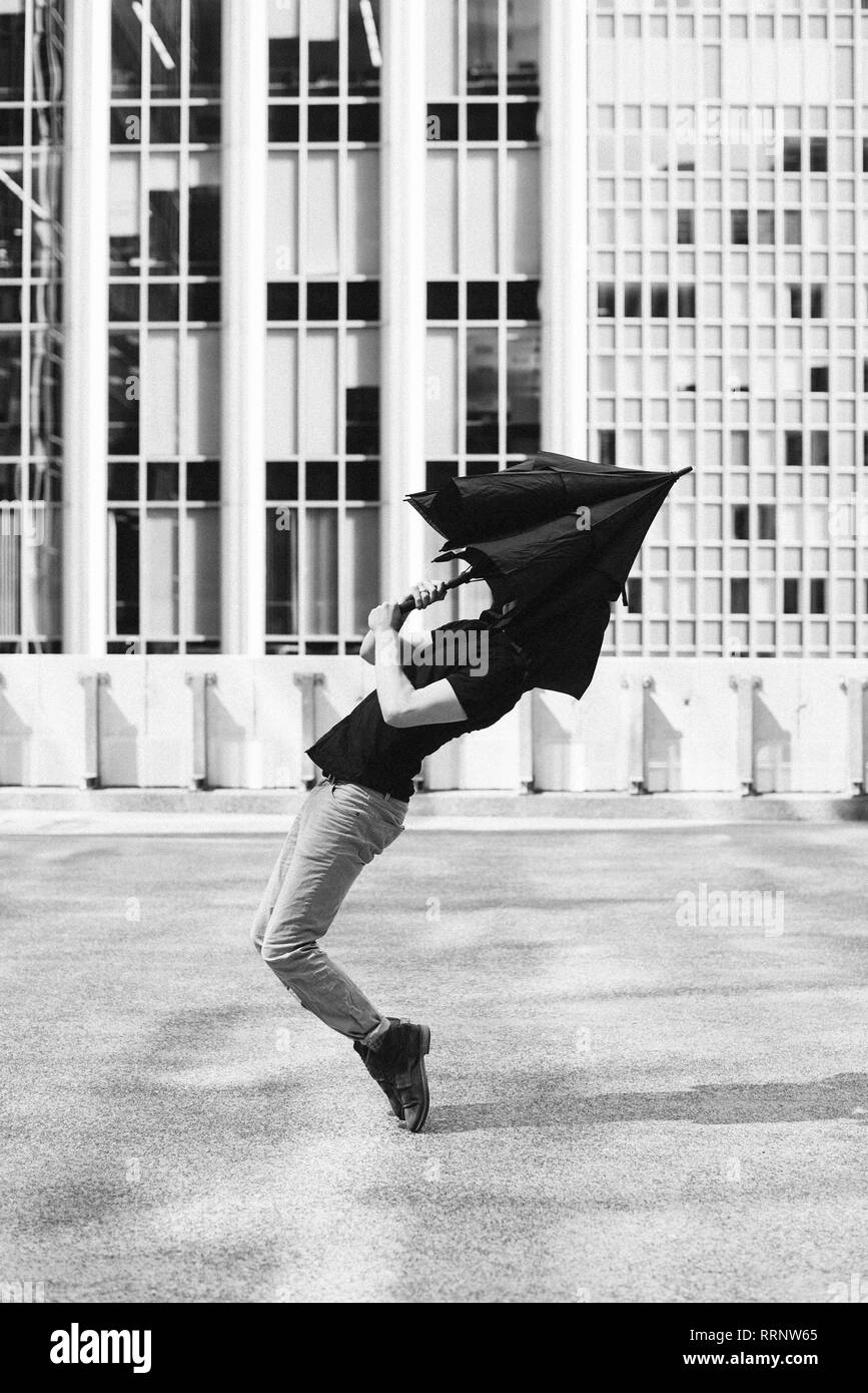 L'uomo ballando con ombrello testa di copertura Foto Stock