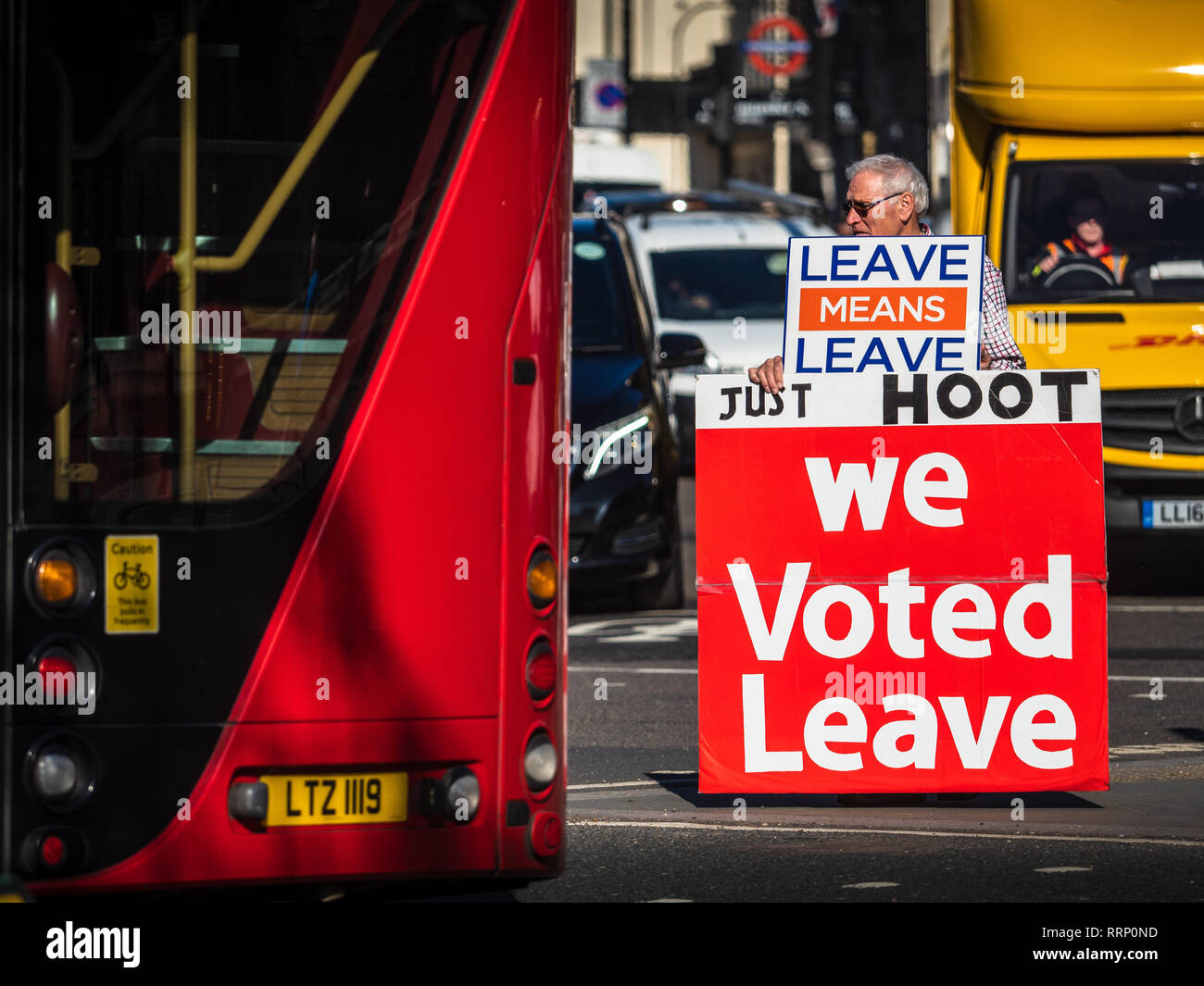 Lasciare Brexit sostenitore sorge nel traffico vicino Piazza del Parlamento nel centro di Londra chiedendo sostenitori per sparare le loro corna a sostegno Foto Stock