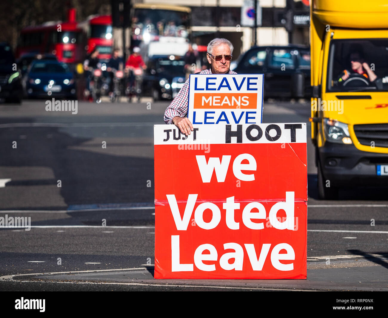 Lasciare Brexit sostenitore sorge nel traffico vicino Piazza del Parlamento nel centro di Londra chiedendo sostenitori per sparare le loro corna a sostegno Foto Stock