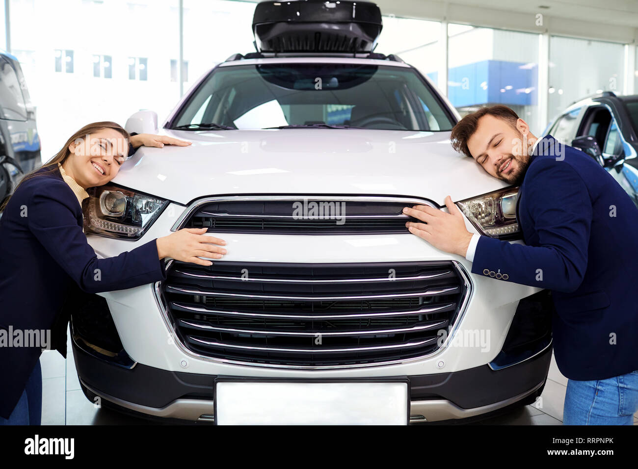 Coppia sorridente abbracciando auto auto in auto salon Foto Stock