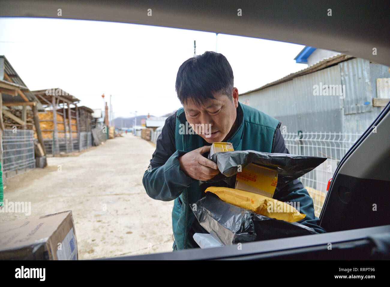 (190226) -- CHANGCHUN, Feb 26, 2019 (Xinhua) -- portalettere Jin Renzhe scarica i pacchi postali in Chunhua township di Huichun City, a nord-est della Cina di provincia di Jilin, Feb 19, 2019. Jin Renzhe ha lavorato come un postino per 30 anni in Chunhua Township, dove il servizio postale è inadeguata a causa dei ripidi sentieri di montagna e liberamente i villaggi sparsi. Nonostante che, Jin riesce a consegnare la posta per gli abitanti di un villaggio lo stesso giorno e-mail arrivano nella città. Come molti giovani lavorano al di fuori della città, Jin ponti a loro e ai loro genitori attraverso la consegna dei pacchi. Vivere con le malattie degli occhi e Artrite, Jin st Foto Stock