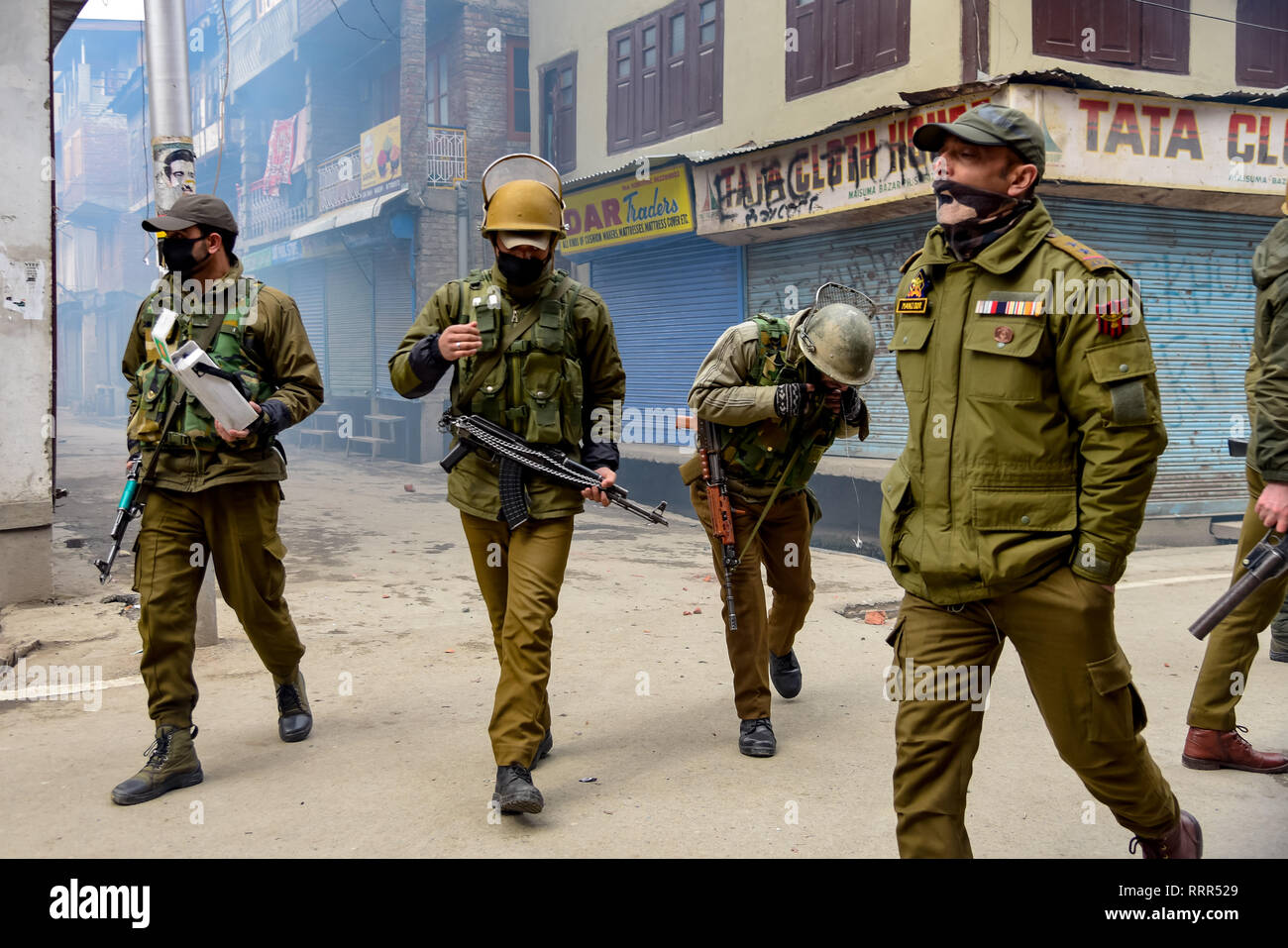 Poliziotti indiani sono visto correre per coprire in mezzo al fumo di strappo durante gli scontri a Srinagar. Le forze indiane in Indian amministrato il Kashmir usato gas lacrimogeni gusci per sedare la protesta contro le incursioni sui principali leader separatista da Indiana funzionari di intelligence. Foto Stock