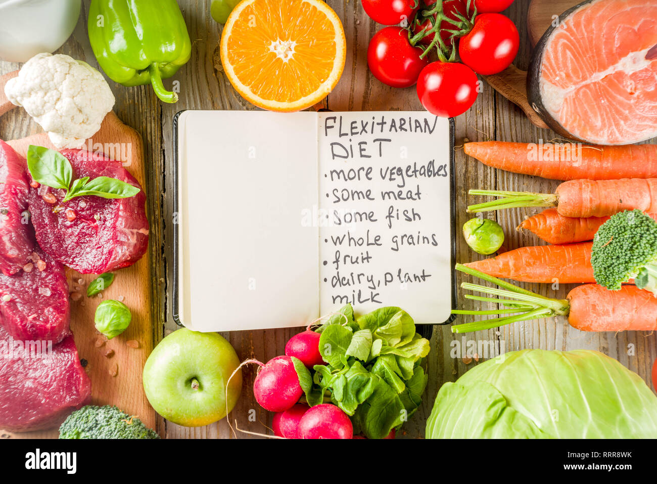 La dieta Flexitarian la dieta con verdure fresche, carne cruda e pesce, legumi, cereali, frutta, sullo sfondo di legno, spazio copia vista superiore Foto Stock