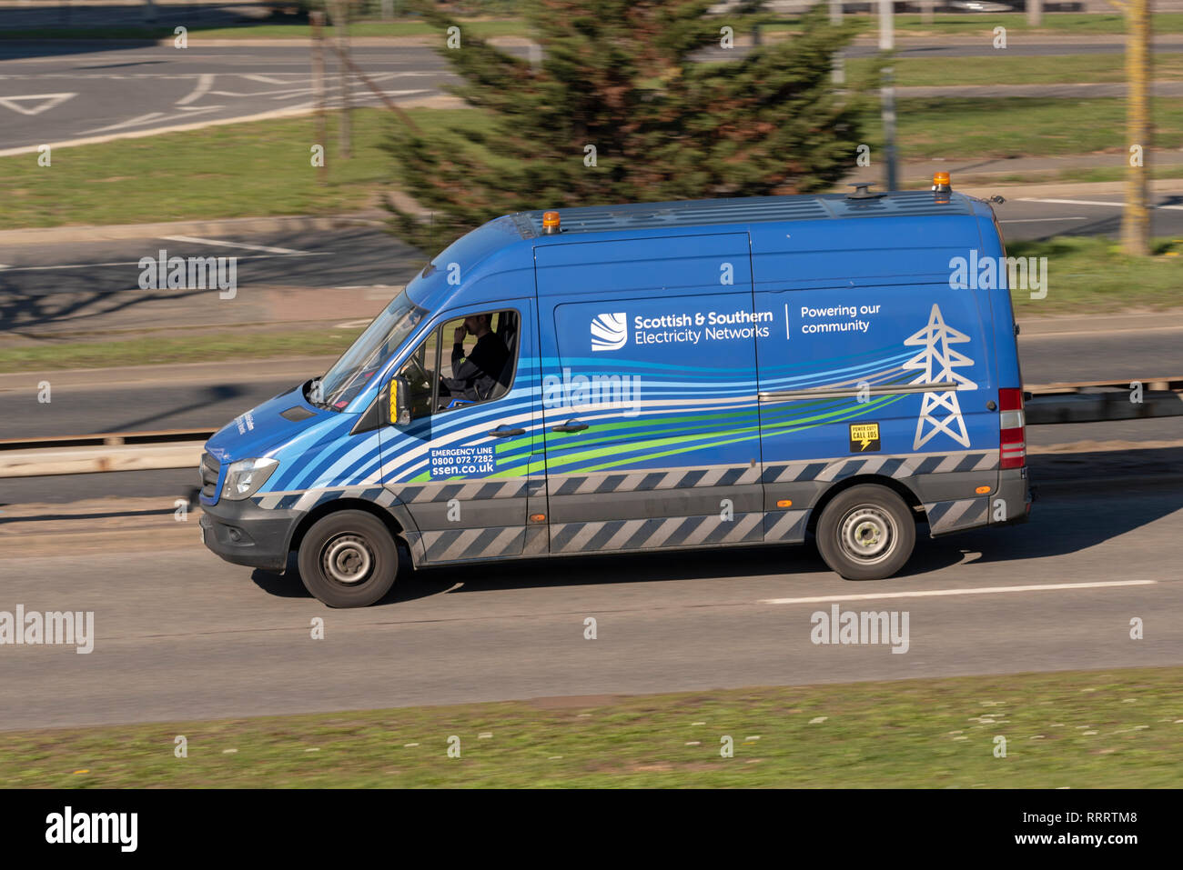 Scozzese e del Sud le reti di elettricità van guida su strada. Alimentare la nostra comunità slogan. Potenza, fornitore di energia. Foto Stock