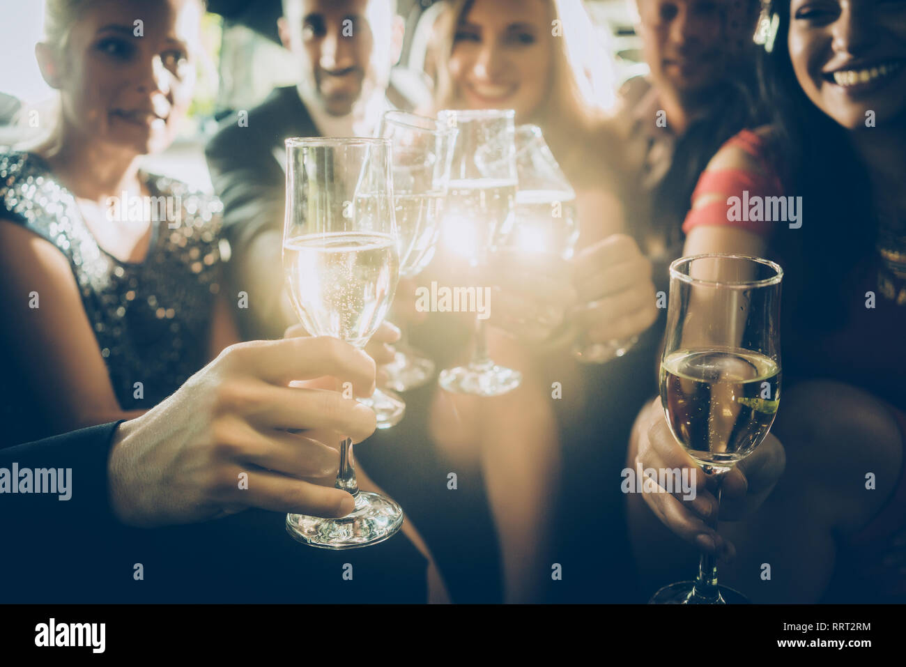 Parte della folla bicchieri tintinnanti con champagne Foto Stock