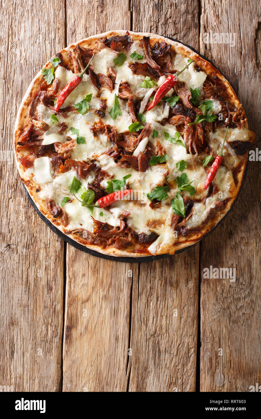 Pizza fresca tirata con carne di maiale, la mozzarella, peperoncino e salsa  barbecue vicino sul tavolo. Verticale in alto vista da sopra Foto stock -  Alamy