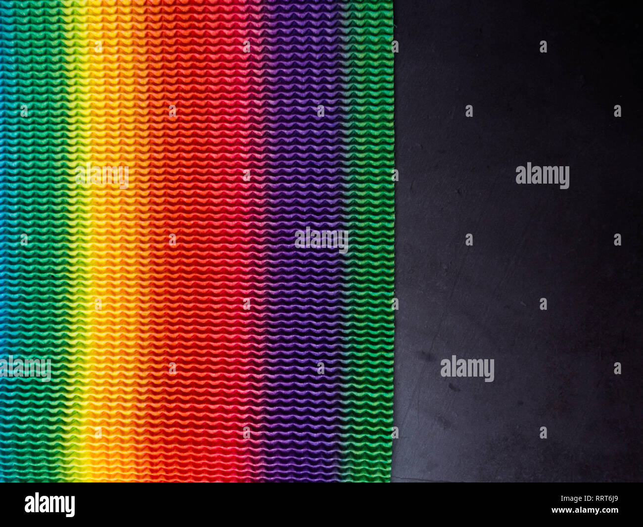 Linee arcobaleno colorato, superficie con spazio copia nero su sfondo di calcestruzzo Foto Stock