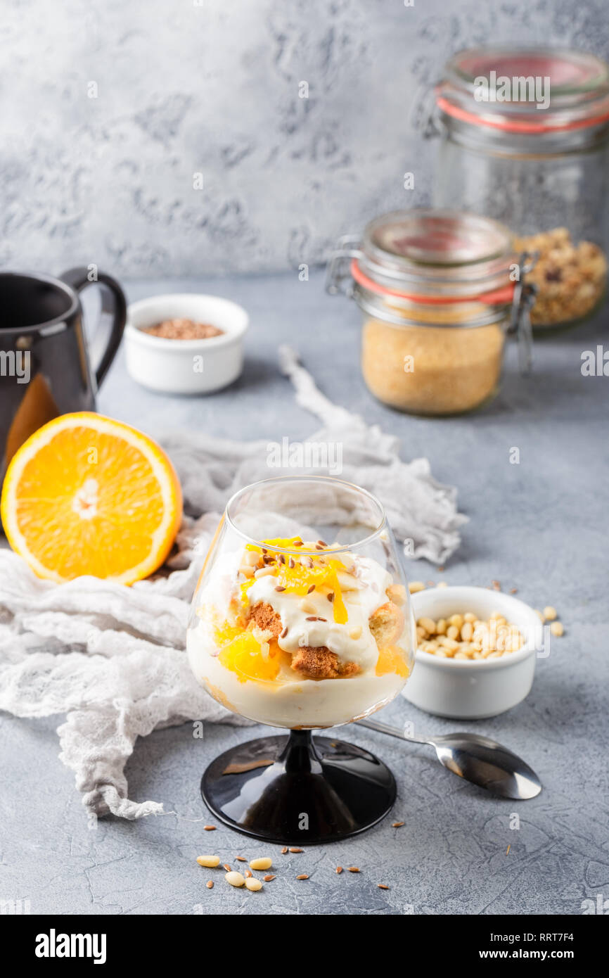 Vetro con una sana in casa dessert stratificata scherzare con Orange, biscotti, yogurt e cereali Foto Stock