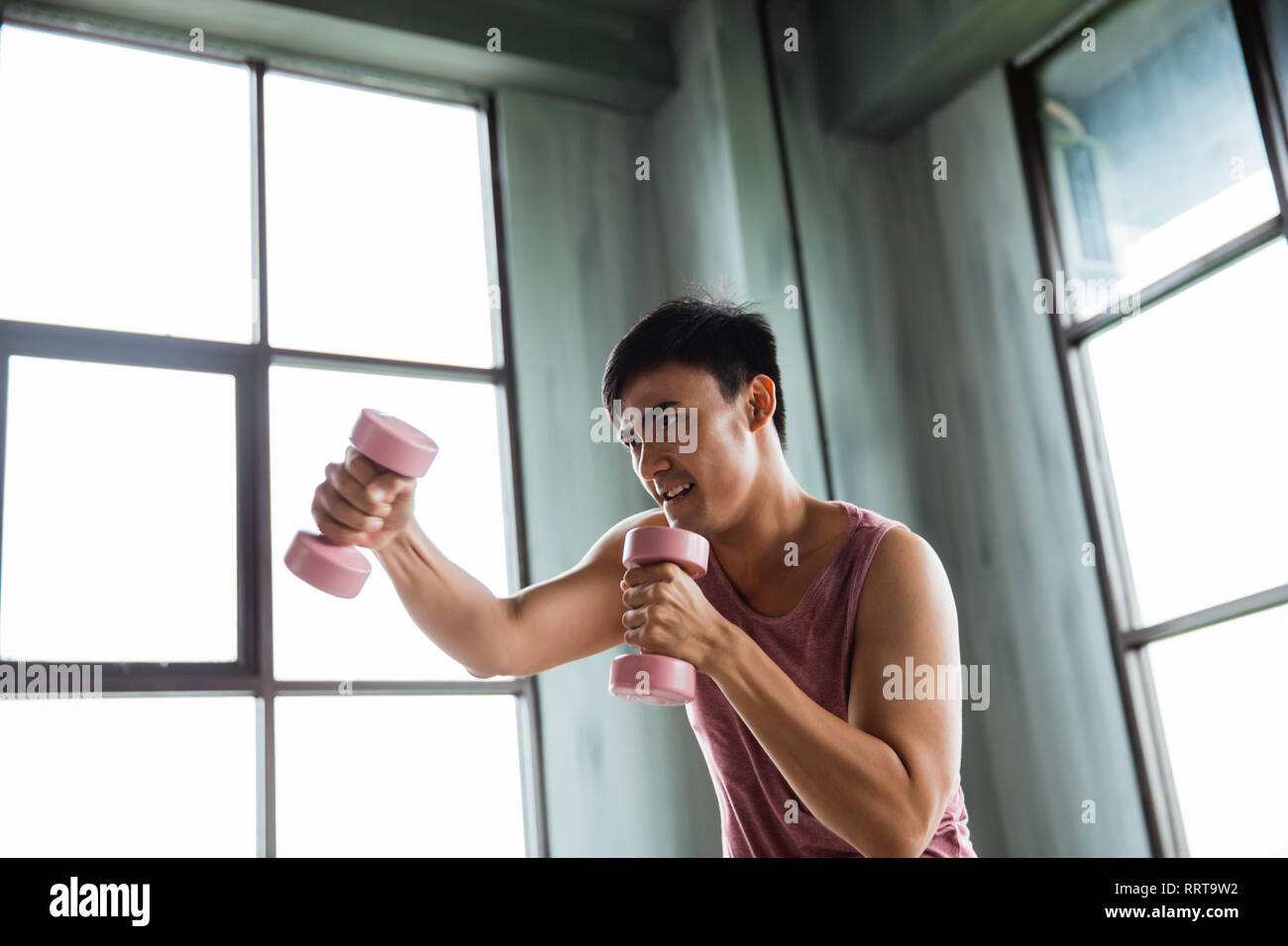 Uomo che utilizza il manubrio facendo qualche esercizio di inscatolamento Foto Stock