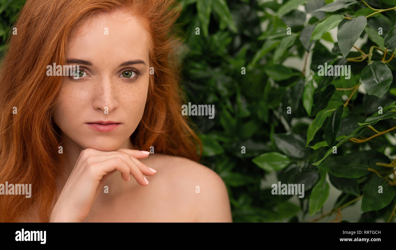Giovane ragazza redhead guardando la fotocamera con pensieroso expression Foto Stock