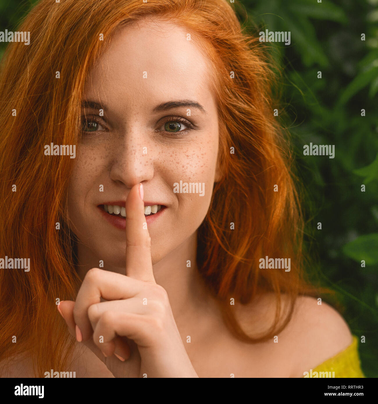 Giovane ragazza redhead che chiedono di mantenere il silenzio Foto Stock
