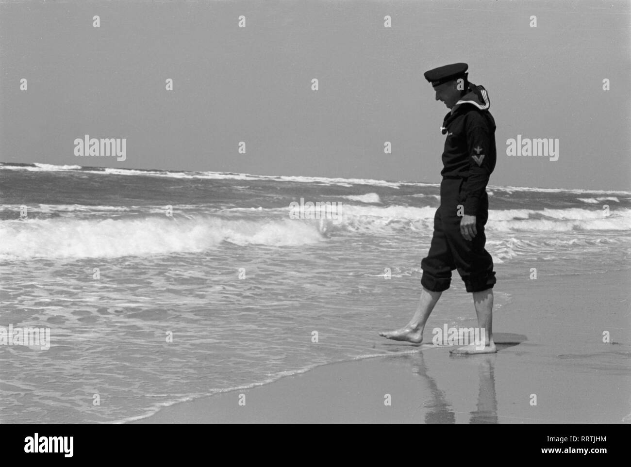 Spiaggia - Strand, Meer, vedere, in Wellen, Belgium.Wellen, sabbia, Mann, Seemann, Matrose, uniforme, barfuss, Schaumkronen, Gischt, marino, Reichsmarine, 1940er, 1940s Foto Stock