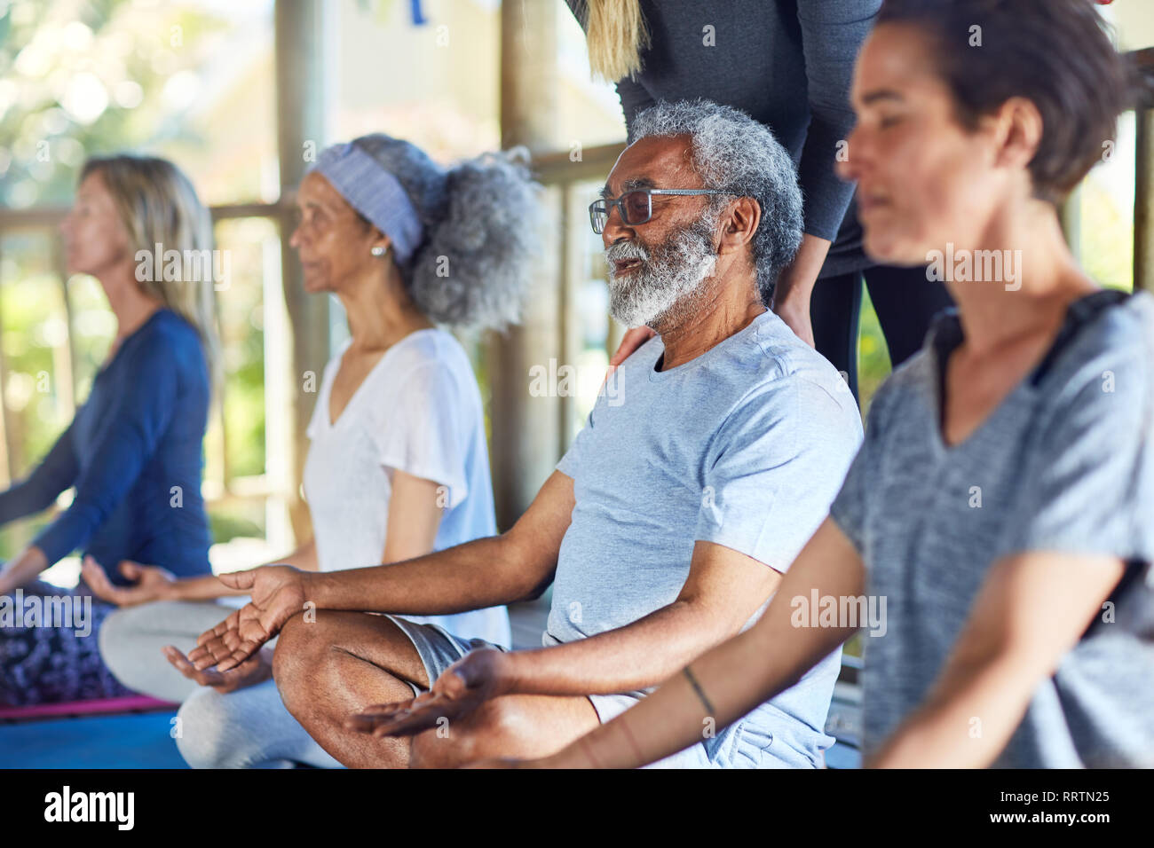Serena senior uomo meditando durante il ritiro di yoga Foto Stock