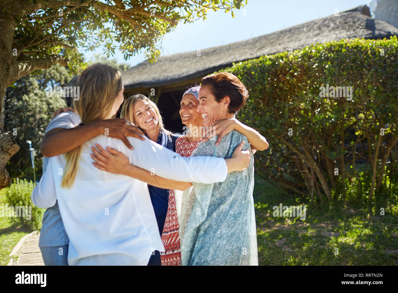 Felici donne amici abbracciando in cerchio Foto Stock