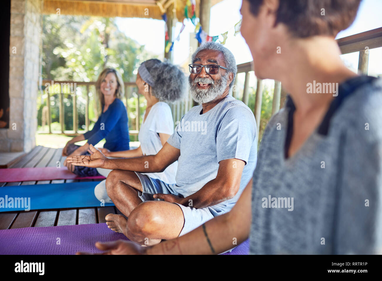 Senior uomo che parla con la donna nella capanna durante il ritiro di yoga Foto Stock