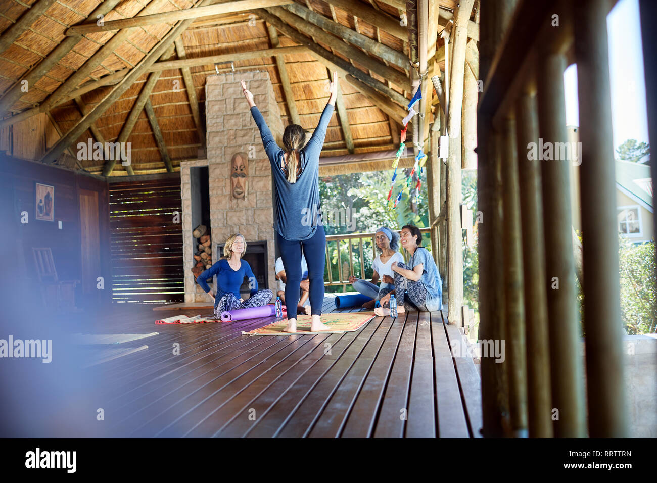 La donna conduce ritiro di yoga in baita Foto Stock