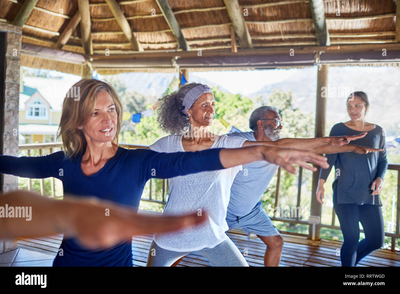 Classe di Yoga pratica warrior 2 pongono nella capanna durante il ritiro di yoga Foto Stock