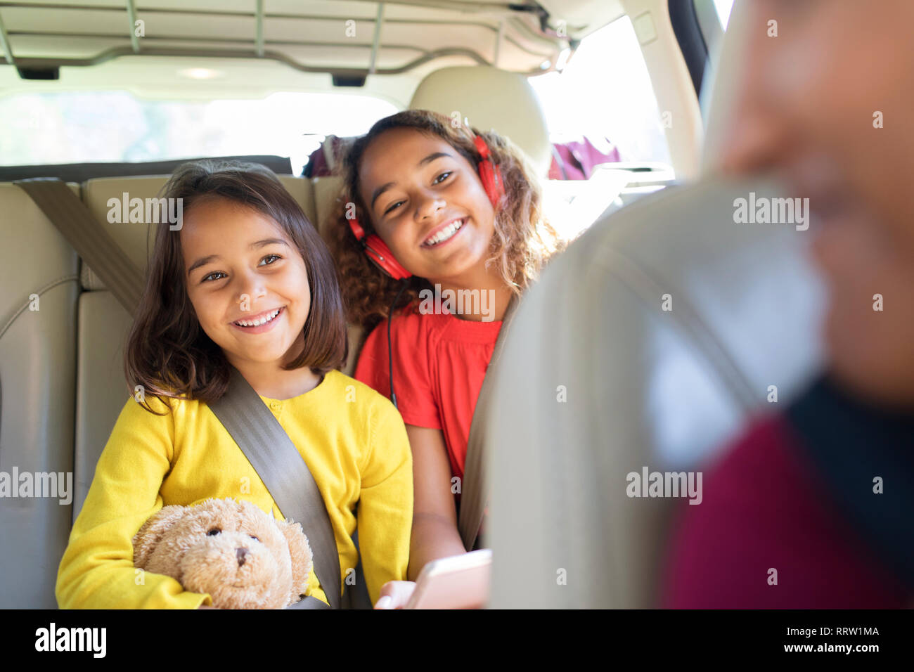 Felice sorelle equitazione nel sedile posteriore della macchina Foto Stock