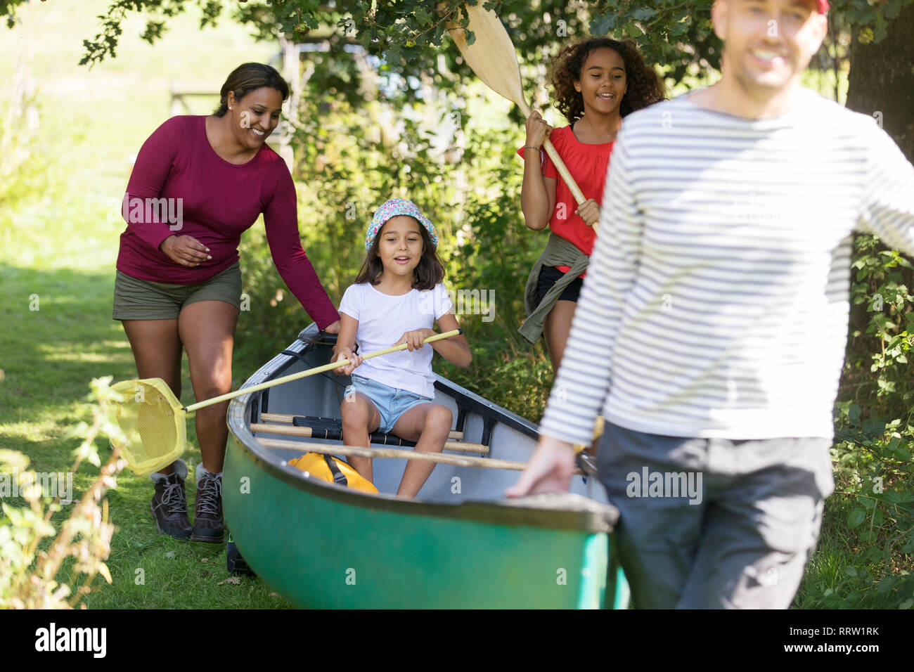 Famiglia portando la canoa nei boschi Foto Stock