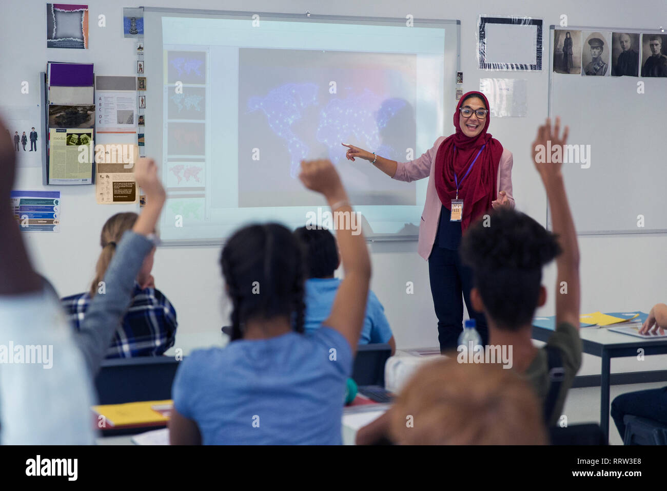 Insegnante femminile in hijab lezione leader a schermo di proiezione in aula Foto Stock