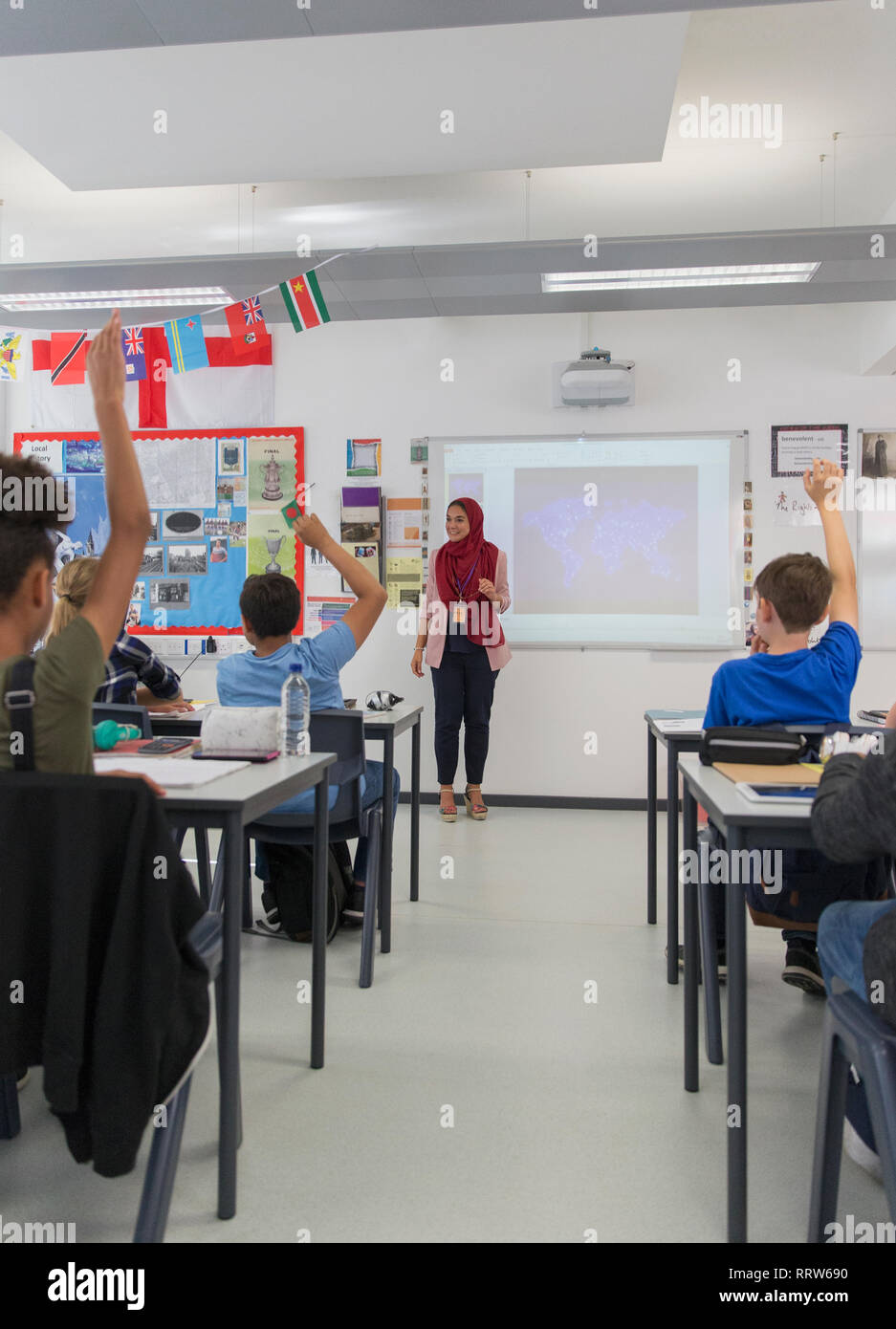 Insegnante femminile in hijab rispondendo alle domande degli studenti in aula Foto Stock