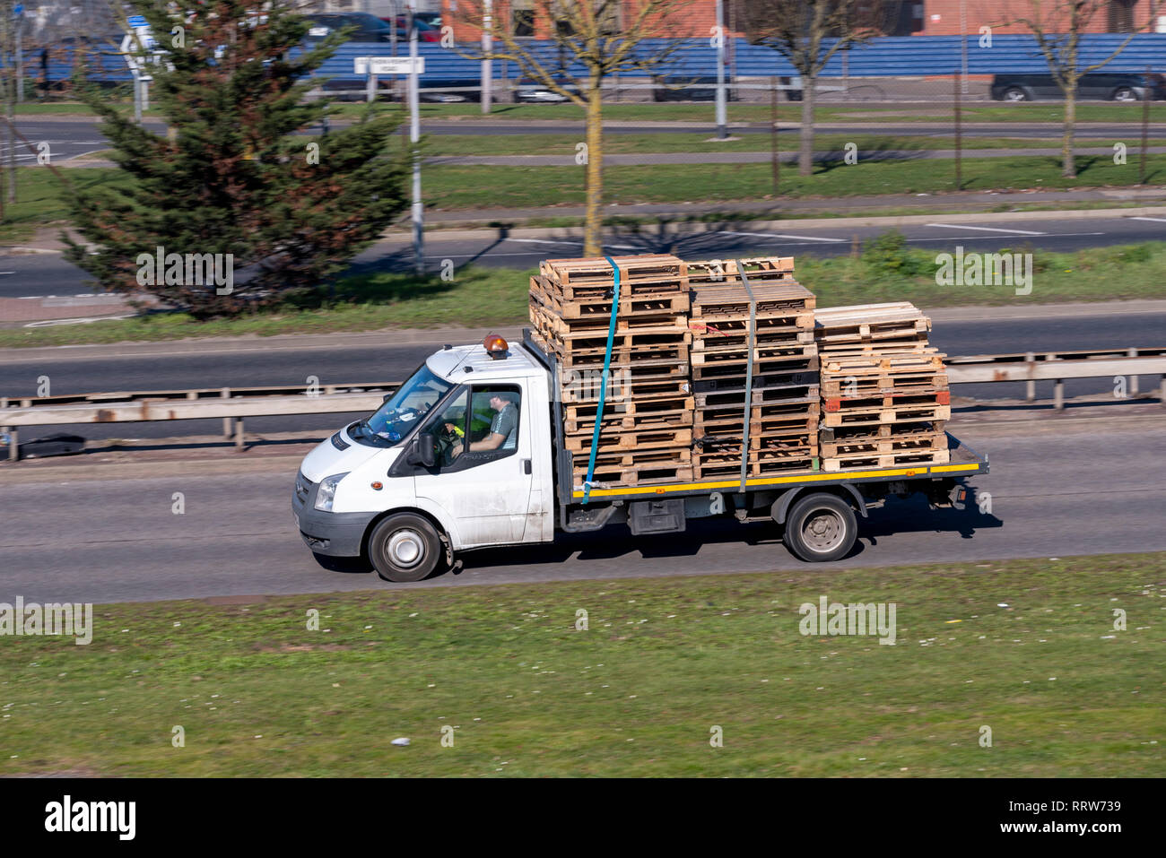 I pallet. Un letto piano transito carrello caricato con una quantità di pallet in legno. La varietà di forme e dimensioni strapped down. Trasporto di pallet Foto Stock I pallet. Un letto piano transito carrello caricato con una quantità di pallet in legno. La varietà di forme e dimensioni strapped down. Trasporto di pallet Foto Stock