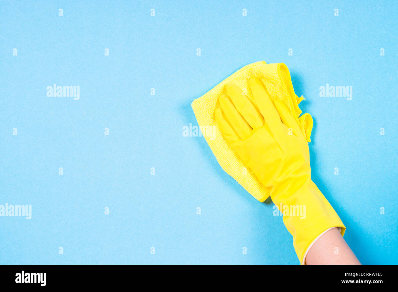 Canto in giallo guanti e panno in microfibra per la pulizia dello sfondo blu. Foto Stock
