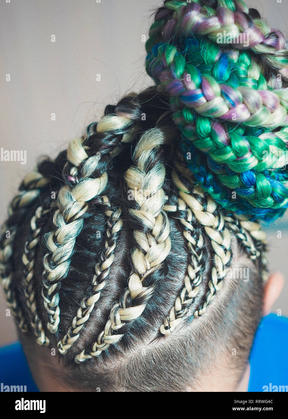 Cornrows donne una donna con un taglio di capelli su uno sfondo bianco, stretto trecce intrecciati con una coda, materiale artificiale tessute in suoi capelli Foto Stock