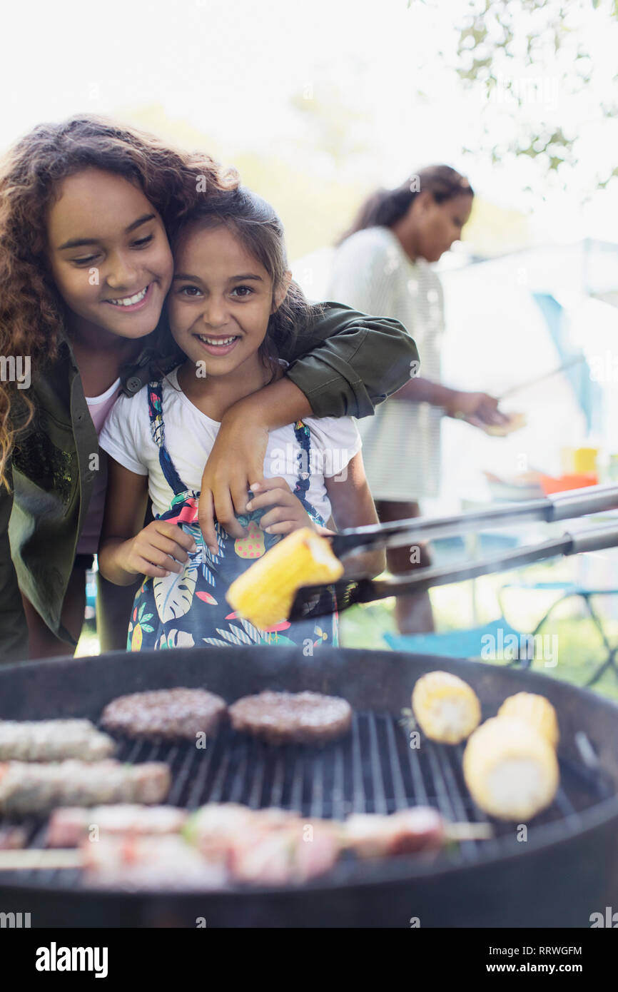 Ritratto affettuoso sorelle godendo barbecue Foto Stock