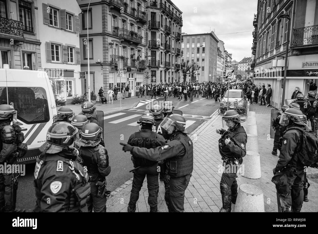Strasburgo, Francia - 8 dicembre 2018: gli ufficiali di polizia che fissano la zona anteriore del Giallo giubbotti di manifestanti di movimento sul Quai des Bateliers street Foto Stock